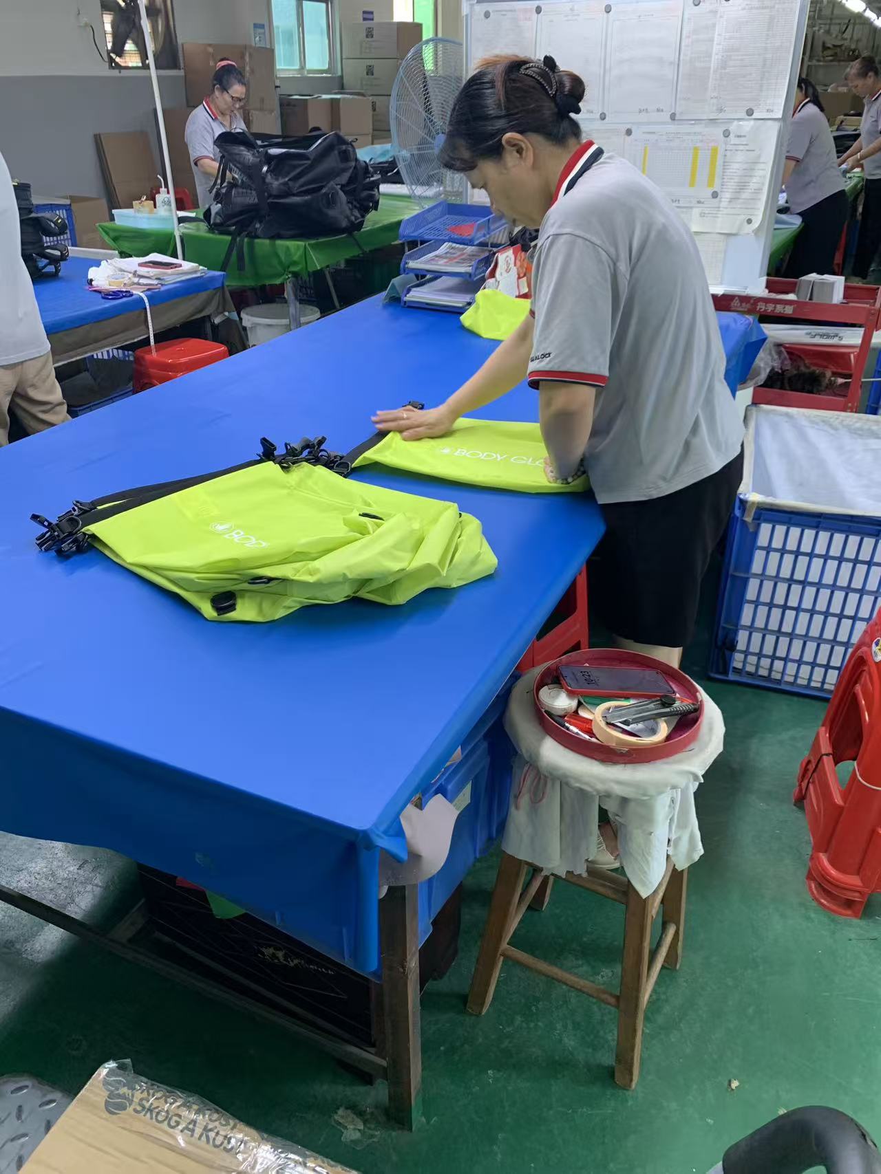 Hoe een bestelling voor een goed zichtbare droge tas met roll-top wordt genaaid, gecontroleerd en in dozen gedaan